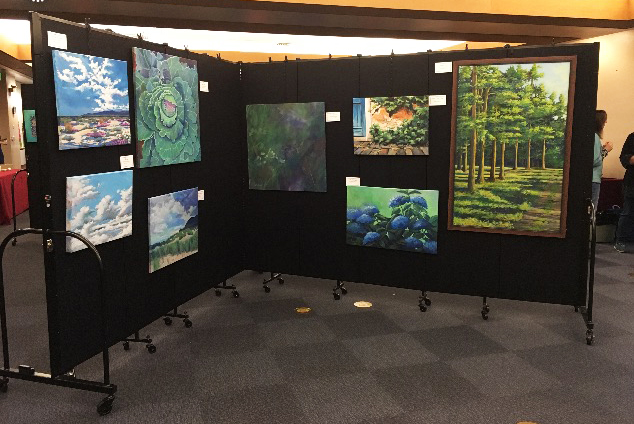 Artwork hung on a black fabric Screenflex Room Divider Artwork hung on a black Screenflex room divider