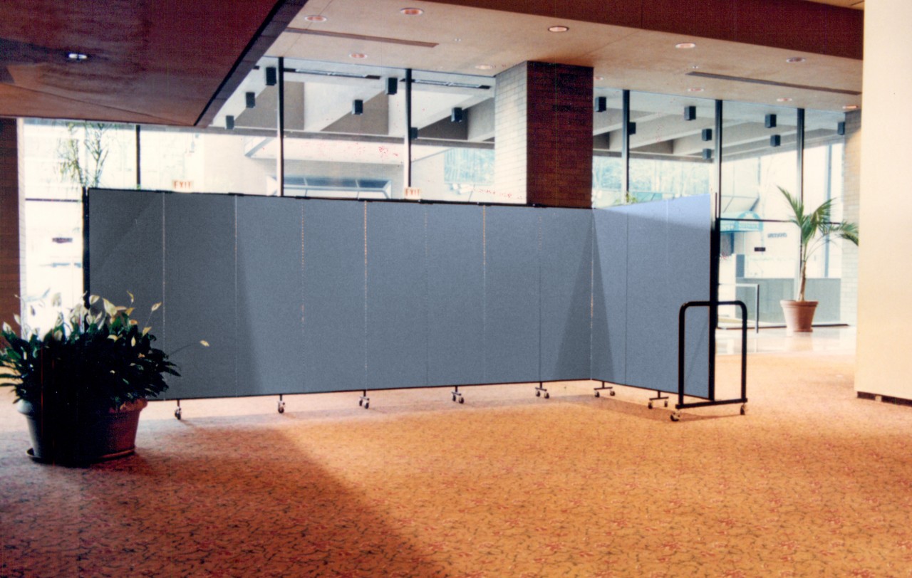 A room divider hides workers changing carpet in a hotel lobby