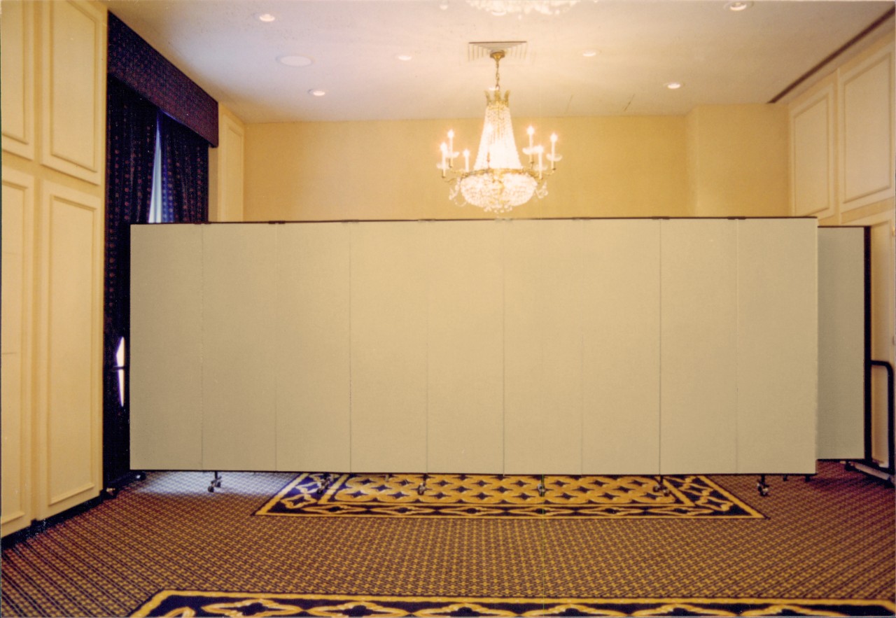 A room divider is opened across the back of a ballroom to hide unused items