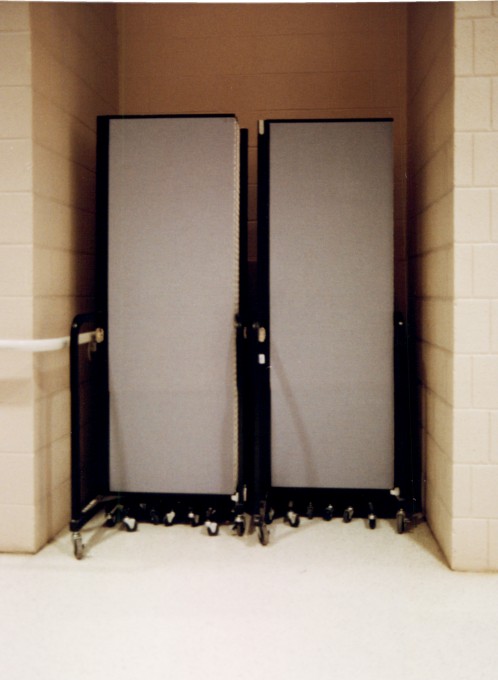 A set of room dividers closed and stored in a wall nook