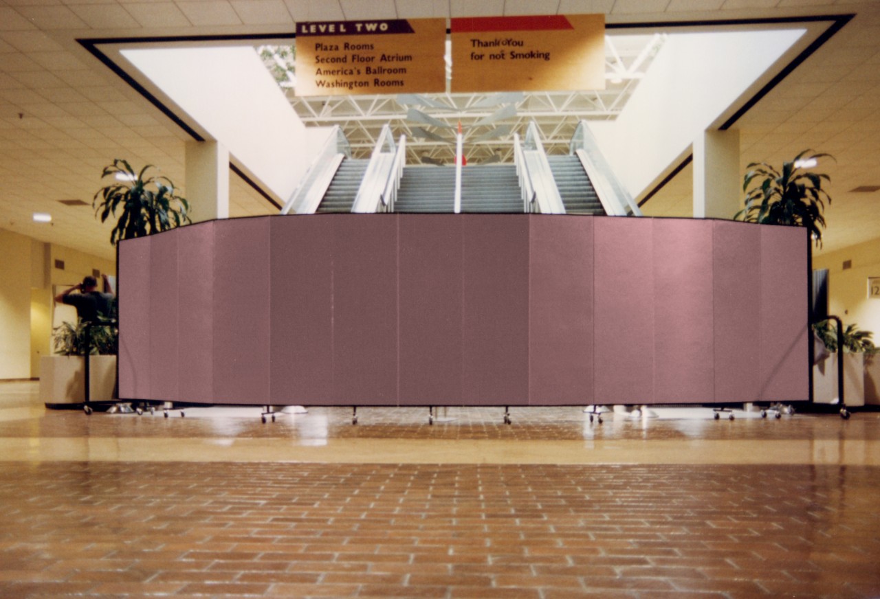 A 13 panel room divider arranged in an arch to deny access to a set of stairs and escalators