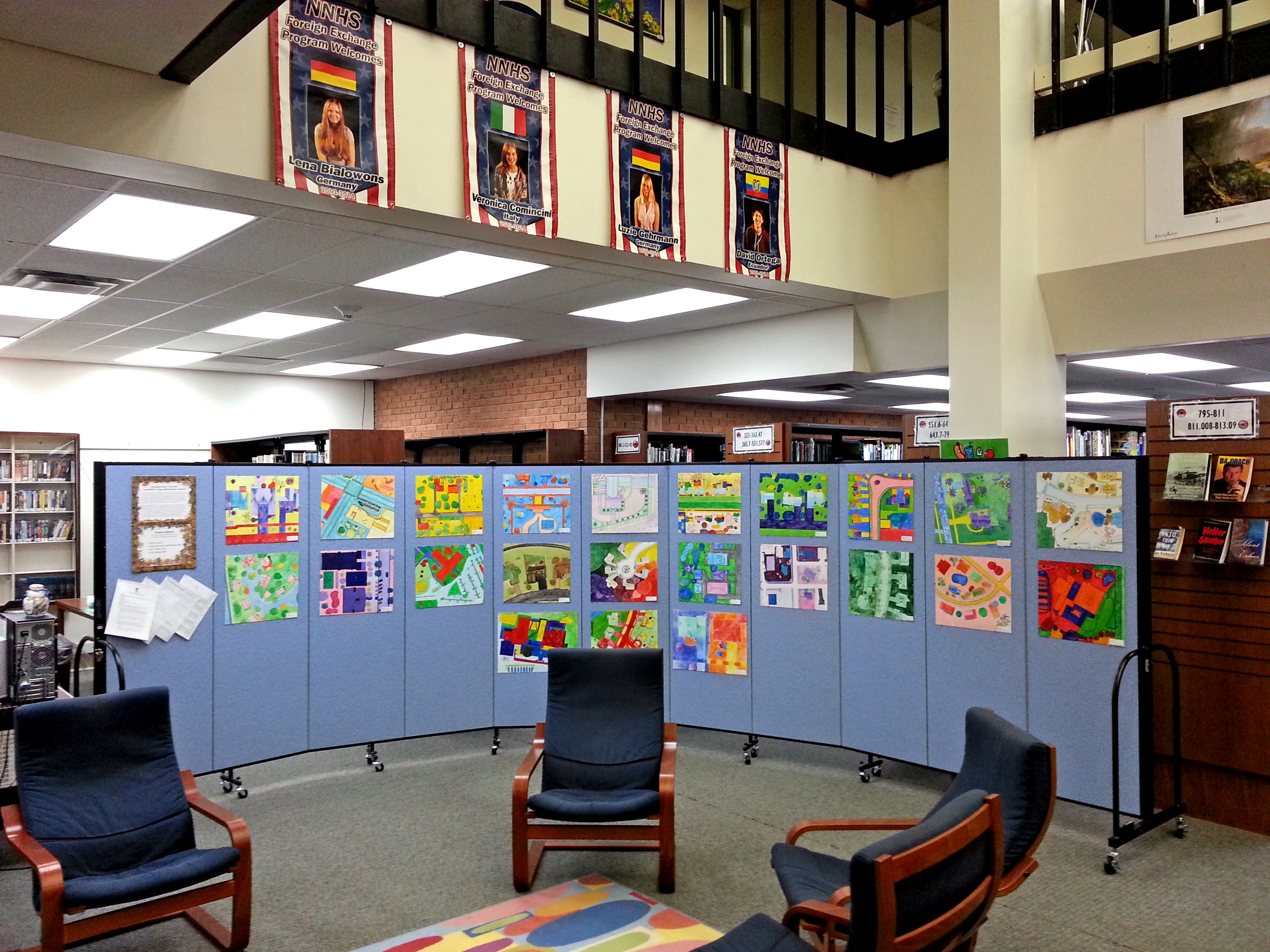 Student artwork displayed on an eleven panel room divider in a school library