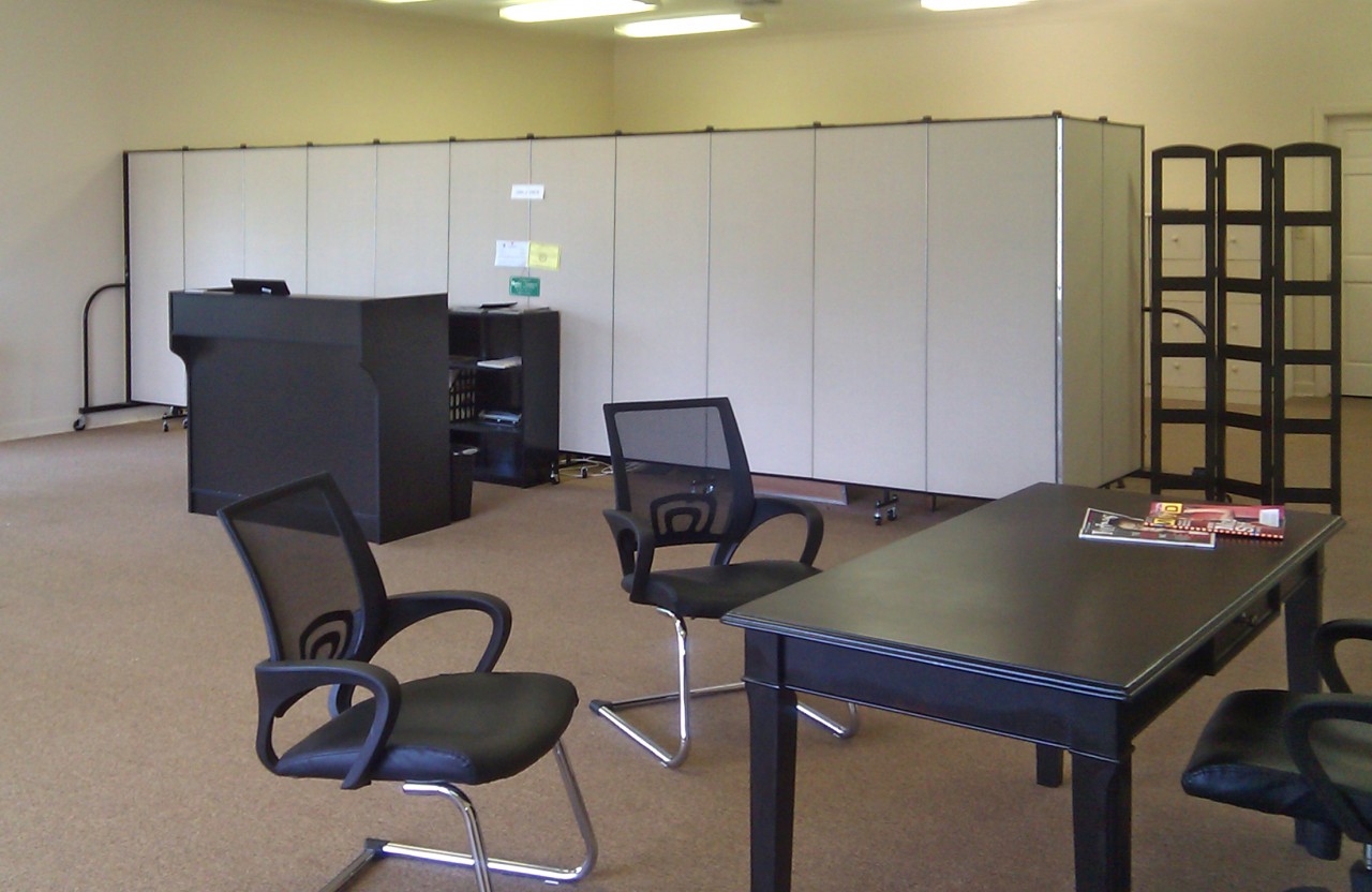 A room divider is used to create private office in the rear of open office space