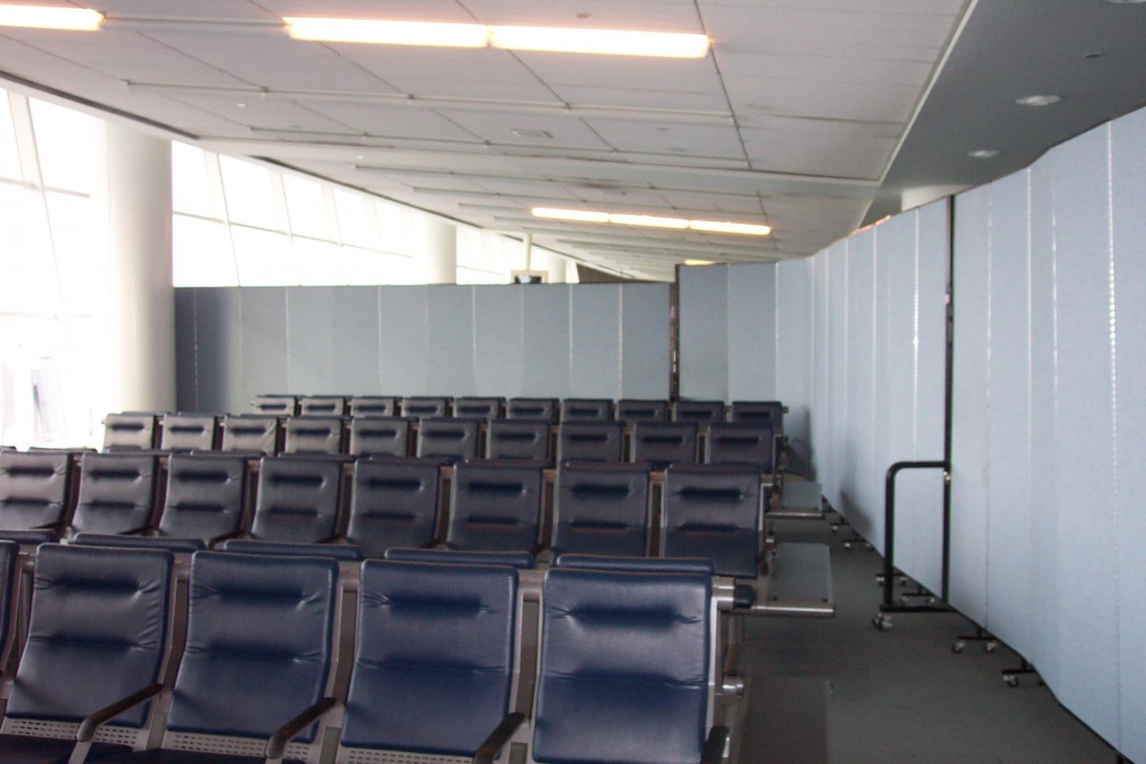 Room dividers surround rows of chairs in an airport waiting area