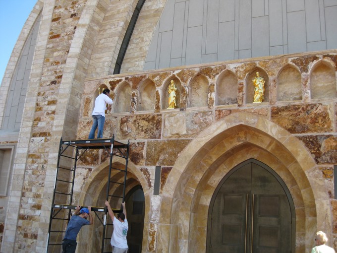 Twelve Golden Disciples being installed on the outside of Ave Maria Church