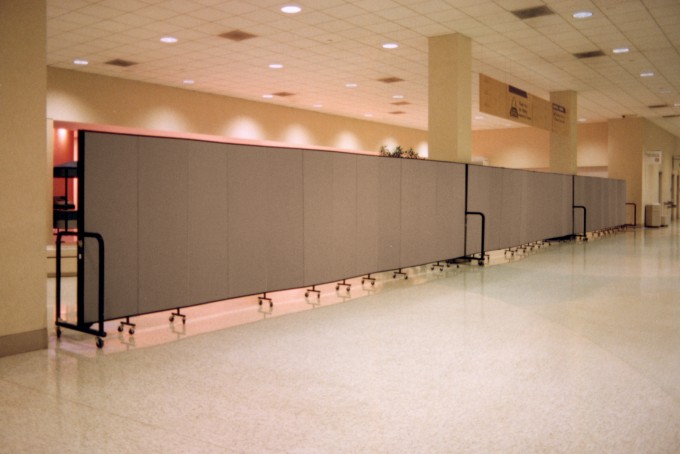 3 Room Divider units are connected to form a long wall separating a construction area from guest services