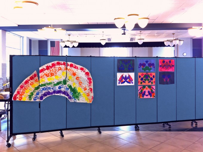 Children's artwork tacked to a Screenflex Room Divider