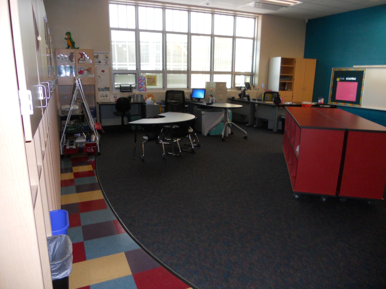 One large classroom cluttered with cabinets and tables and chairs.