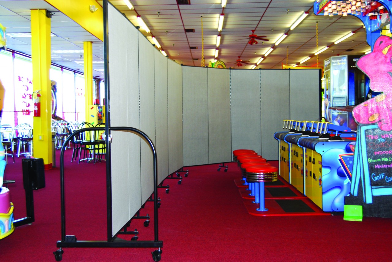 Screenflex Room Divider separates cafeteria from game room at an indoor game center.