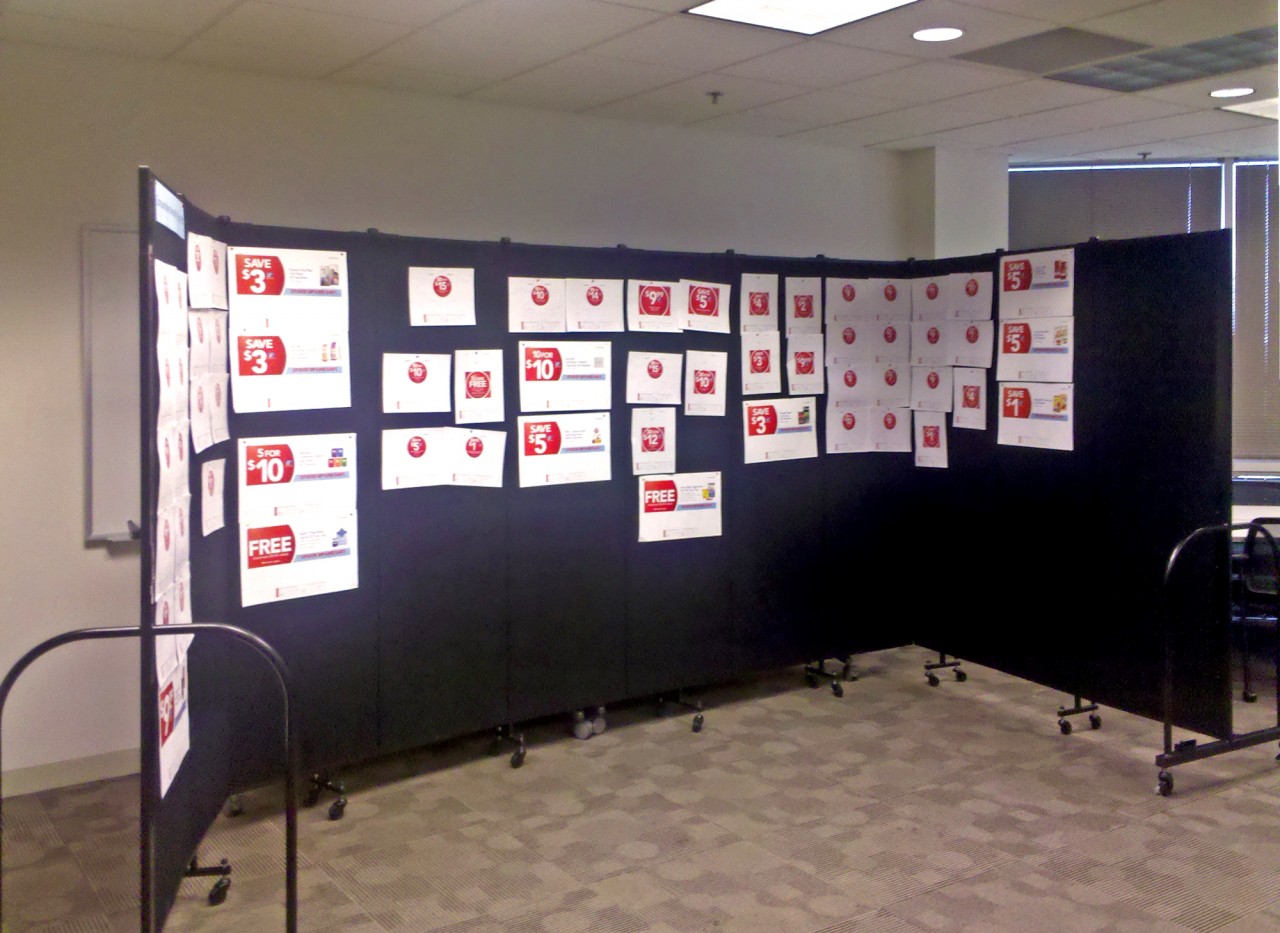 Storyboard presentation displayd on black Screenflex Room Dividers in an office hallway.