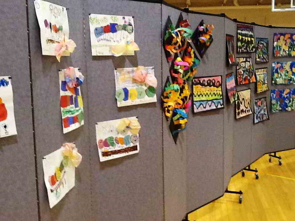 A closeup of student artwork pinned to a Screenflex Room Divider in Lake fabric Colors