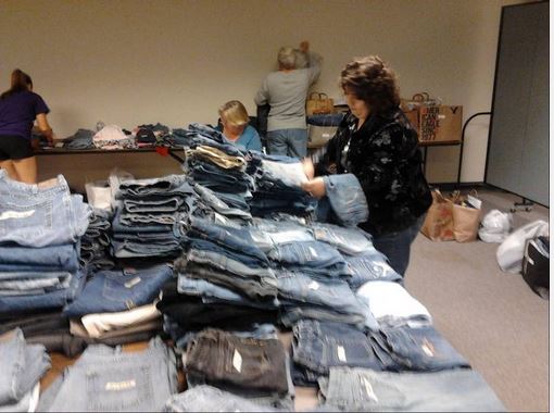 Volunteers sorting jeans for charity project