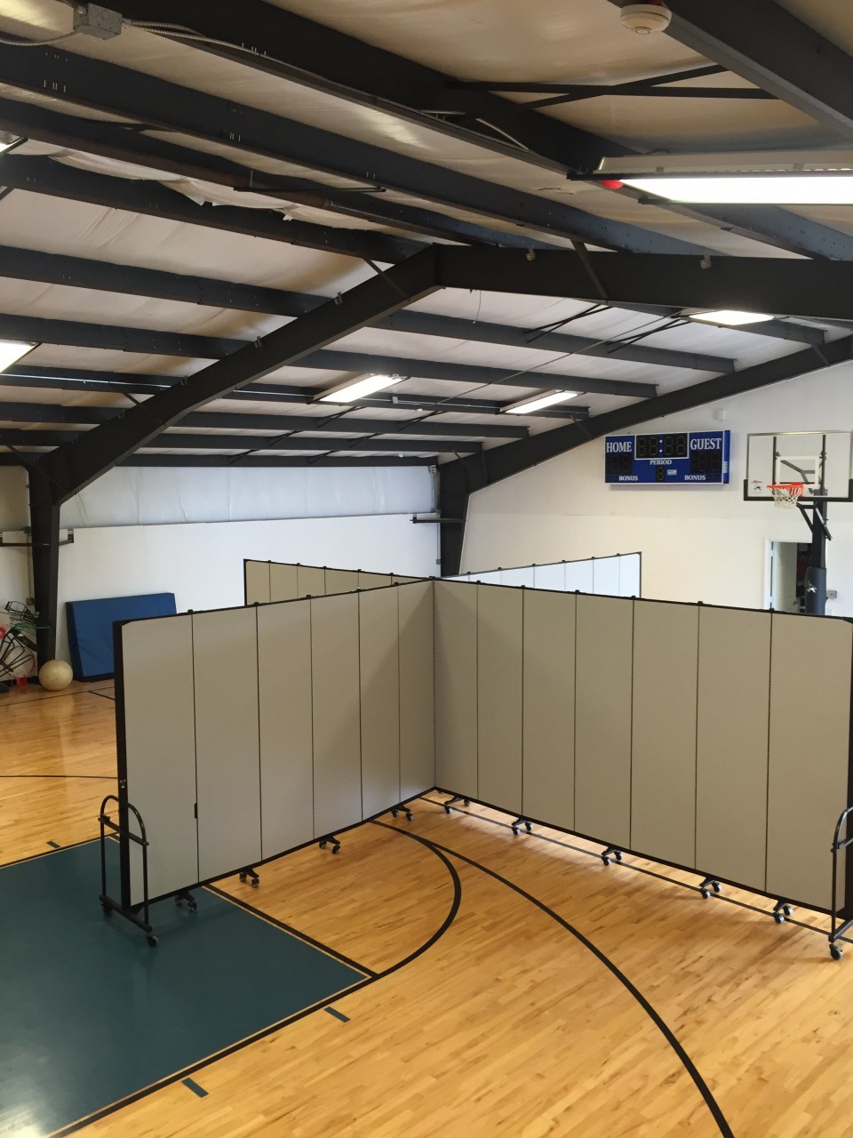 Two room dividers are connected to create 4 rooms in a gym