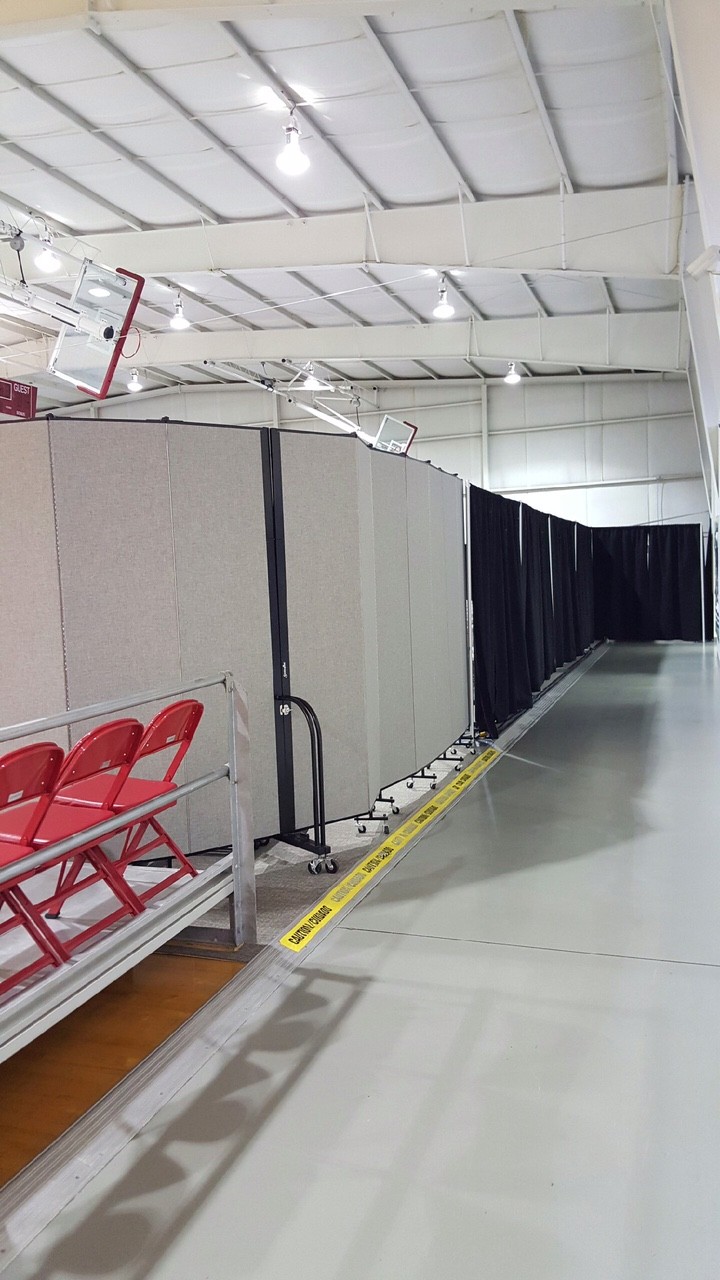 Room Dividers are lined up to create a play area for the youth in a gym