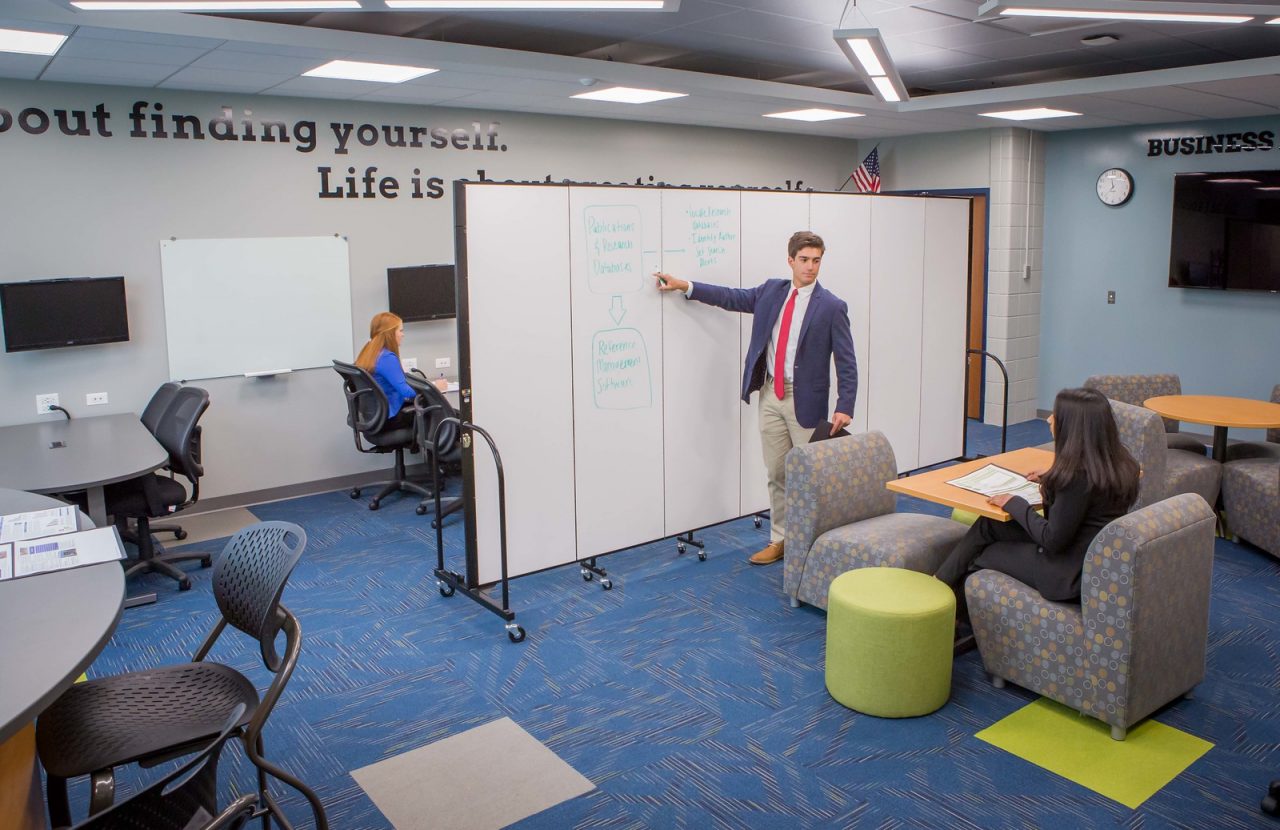 Staff use a moveable office partition to divide meeting space