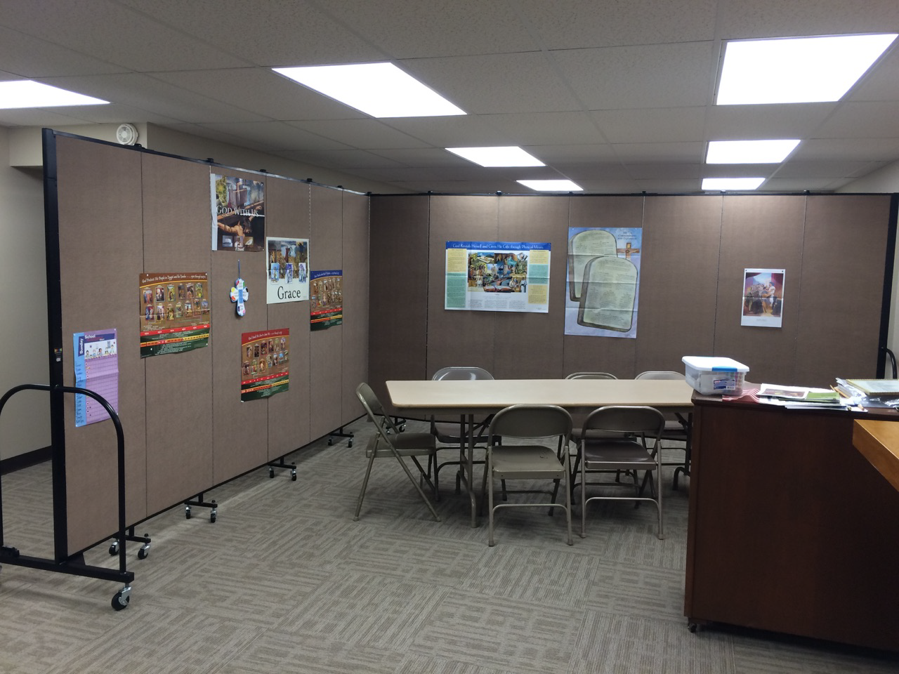 A room divider on wheels sections off a portion of a church to create a Sunday school classroom