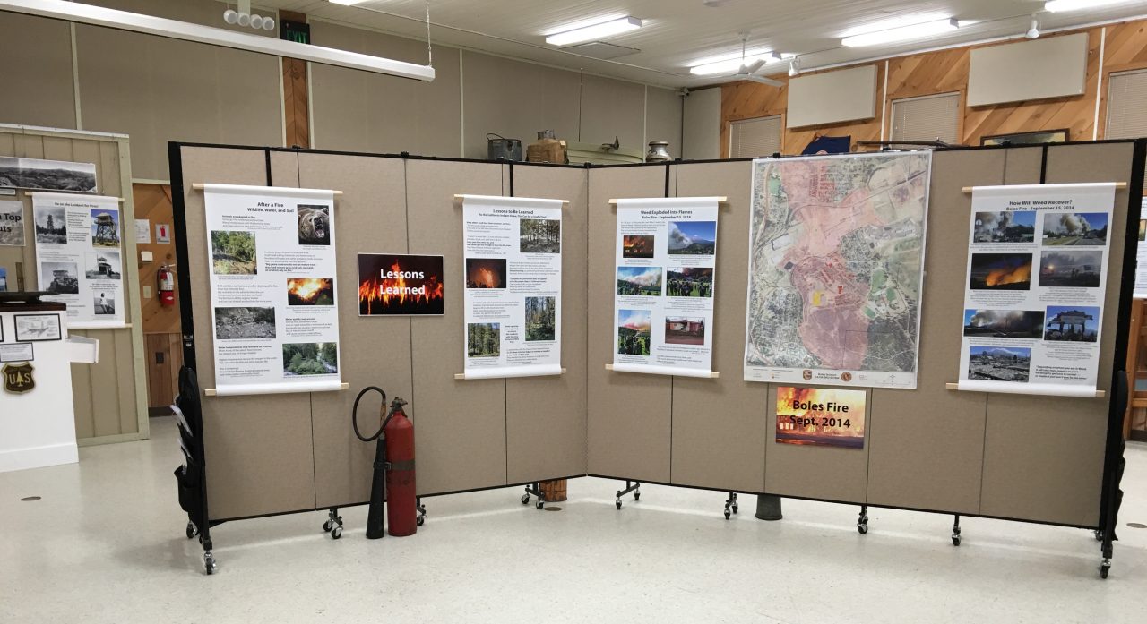 Fire education posters are tacked to a portable wall in a museum