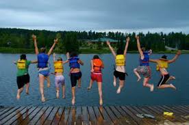 Children jump into a lake off a pier